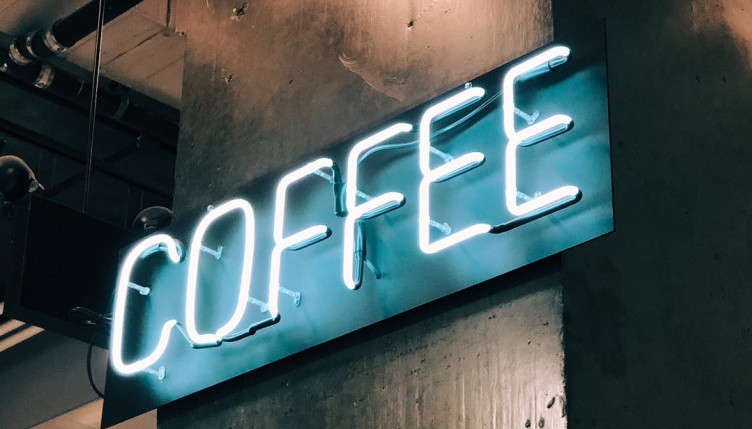 A neon sign advertising coffee for sale